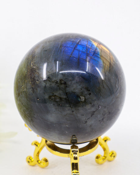 Genuine 303g Labradorite Crystal Sphere with brilliant blue and gold flash displayed on a decorative gold stand.