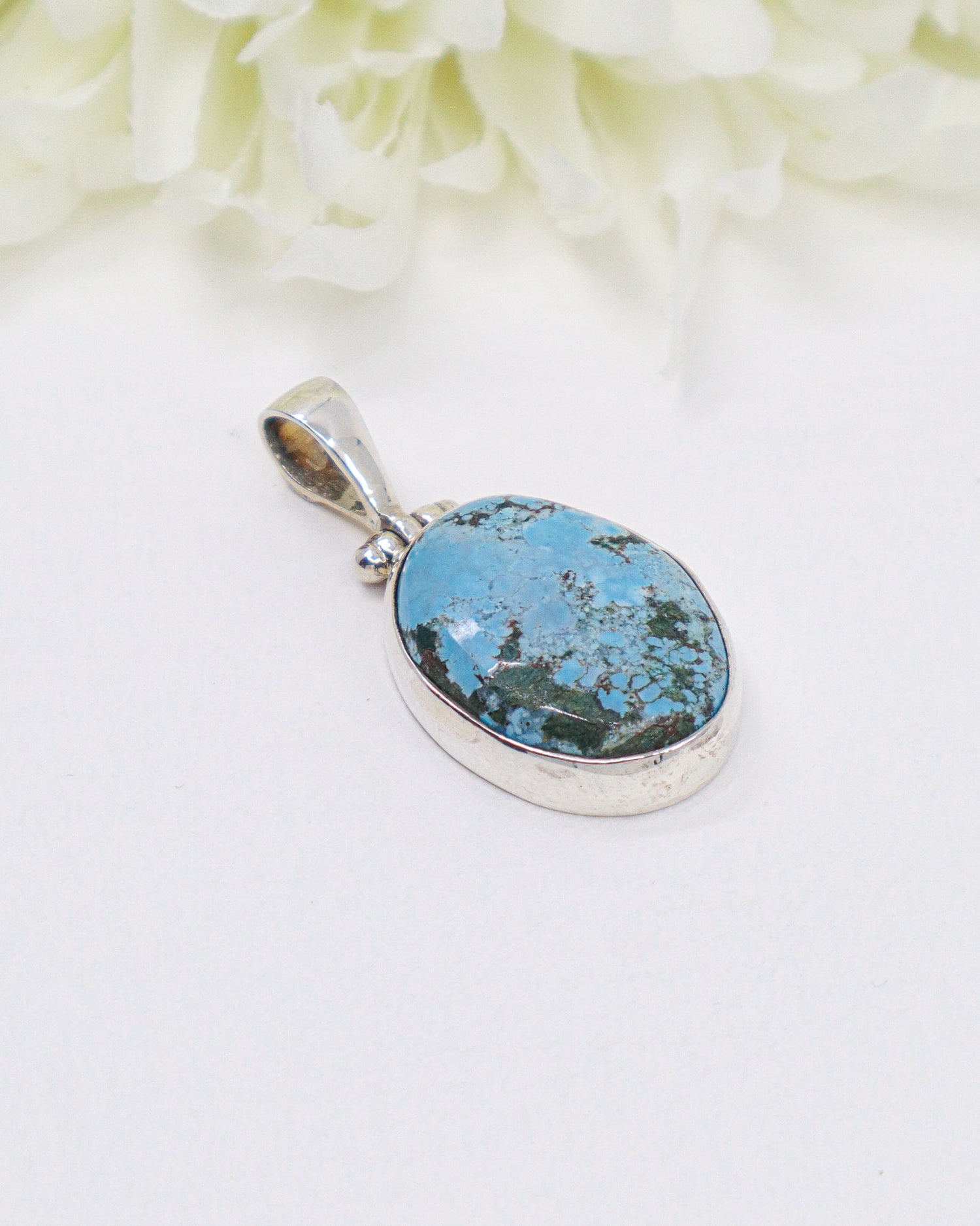 Oval turquoise sterling silver pendant featuring natural sky-blue stone with earthy matrix patterns in a polished silver setting.
