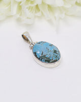 Oval turquoise sterling silver pendant featuring natural sky-blue stone with earthy matrix patterns in a polished silver setting.