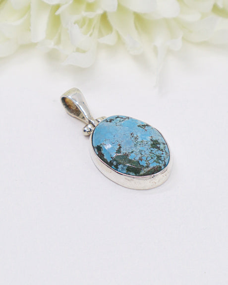 Oval turquoise sterling silver pendant featuring natural sky-blue stone with earthy matrix patterns in a polished silver setting.