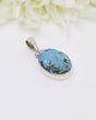 Oval turquoise sterling silver pendant featuring natural sky-blue stone with earthy matrix patterns in a polished silver setting.