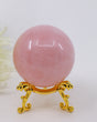Natural Rose Quartz Crystal Sphere weighing 257g with soft pink colouring, polished finish and gold display stand for emotional healing, love and Heart Chakra meditation.