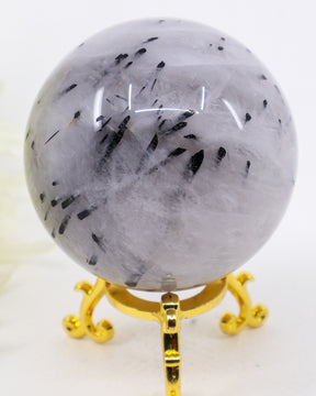 Natural Black Tourmalinated Quartz Crystal Sphere 363g with striking black tourmaline inclusions in polished clear quartz on a gold display stand.