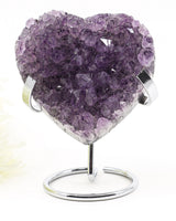 Natural Amethyst Crystal Heart displayed on a metal stand featuring deep purple druzy crystal formations associated with emotional healing, harmony and spiritual growth.