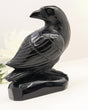 Hand-carved Black Obsidian Raven crystal carving with detailed feather engravings and glossy polished finish on carved Obsidian base.