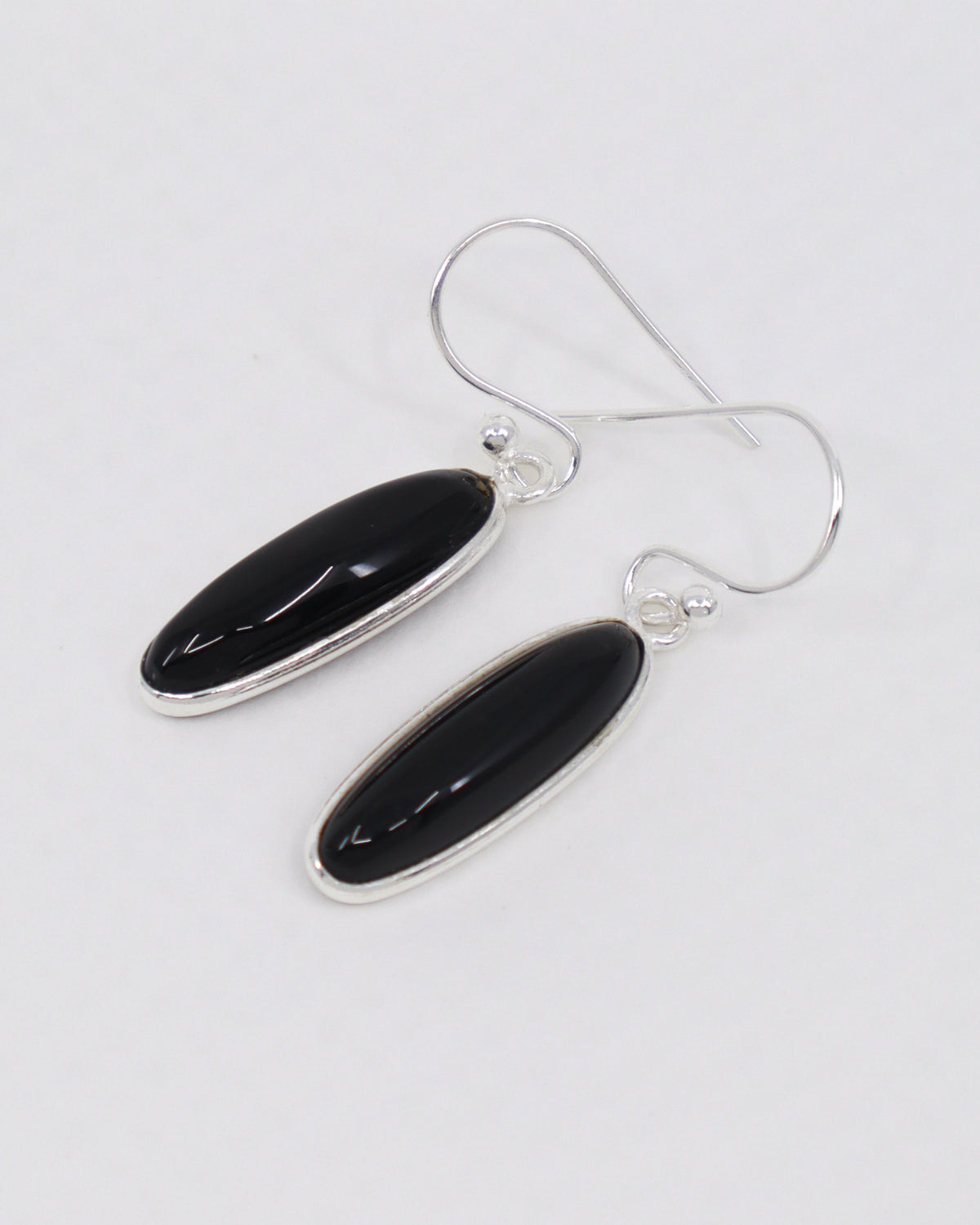 Black Onyx sterling silver drop earrings with polished elongated oval gemstones in .925 silver, grounding protection crystal jewellery Australia.