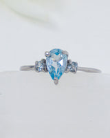 Blue Topaz sterling silver ring Size 8 with pear-cut blue gemstone and sparkling side stones in .925 silver.