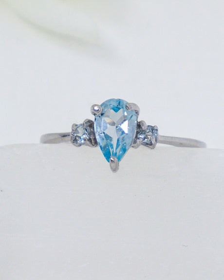 Blue Topaz sterling silver ring Size 8 with pear-cut blue gemstone and sparkling side stones in .925 silver.