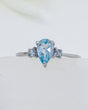 Blue Topaz sterling silver ring Size 8 with pear-cut blue gemstone and sparkling side stones in .925 silver.