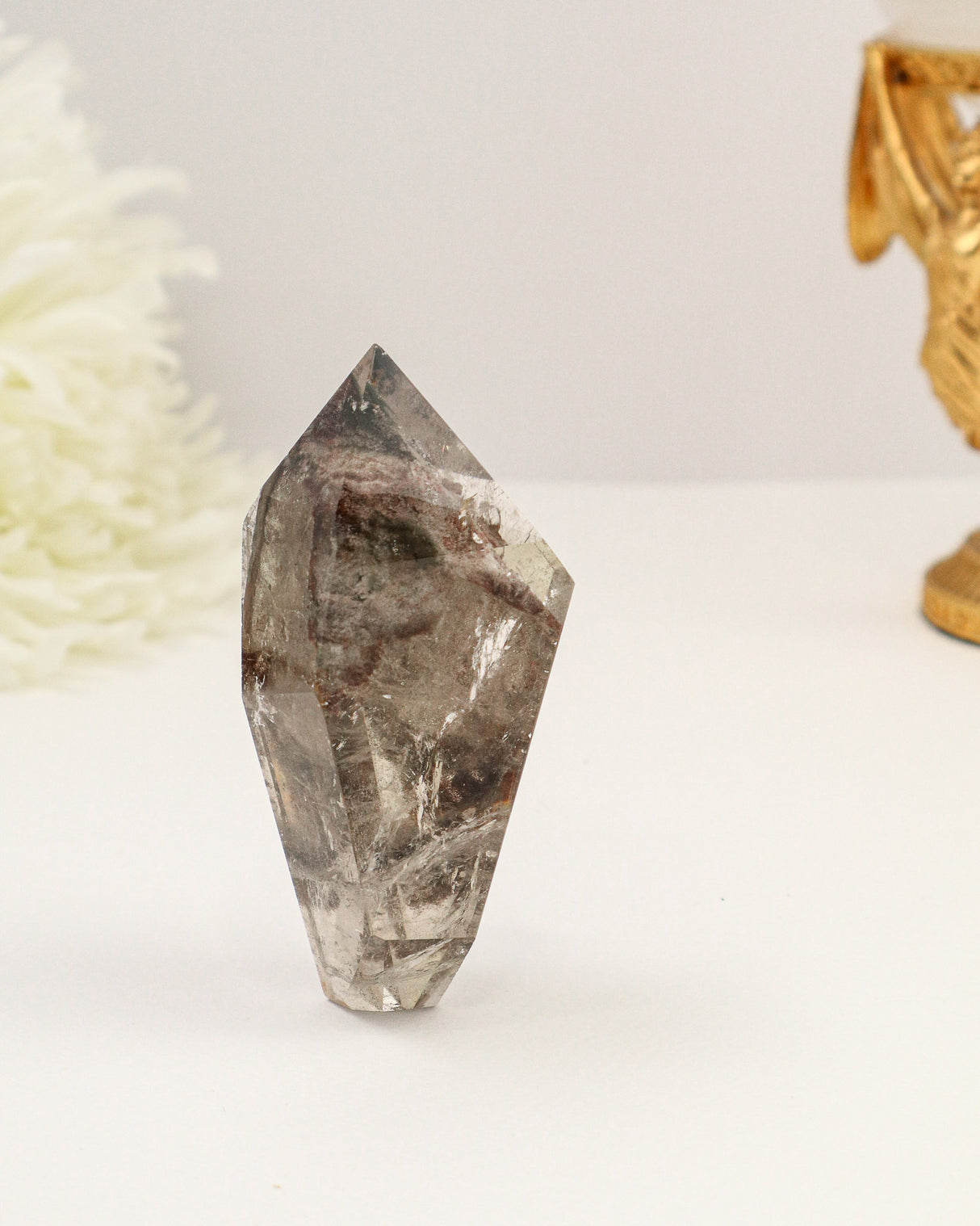 Polished Garden Quartz freeform point featuring smoky natural inclusions and scenic internal formations.