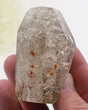 Garden Quartz Lodolite crystal 125g featuring white scenic mineral formations, rusty-orange inclusions and polished angled termination.