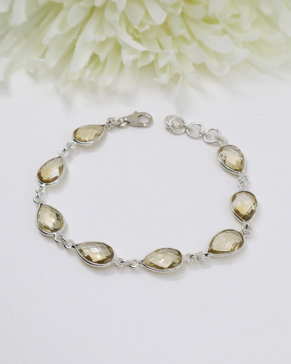 Sterling silver Citrine bracelet with larger faceted golden teardrop gemstones displayed beside ruler for size reference.
