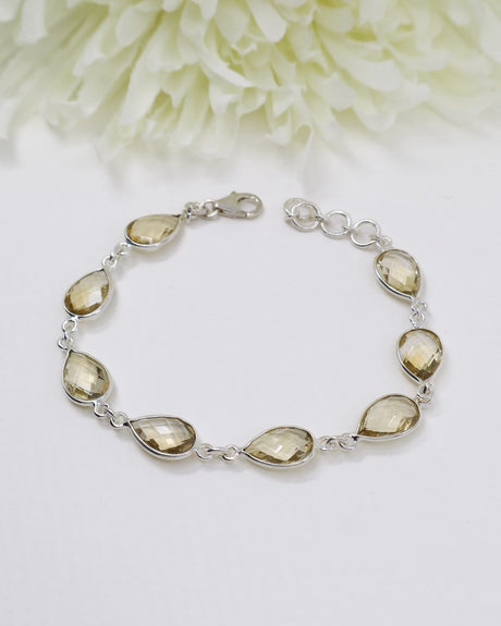 Sterling silver Citrine bracelet with larger faceted golden teardrop gemstones displayed beside ruler for size reference.