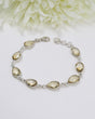 Sterling silver Citrine bracelet with larger faceted golden teardrop gemstones displayed beside ruler for size reference.