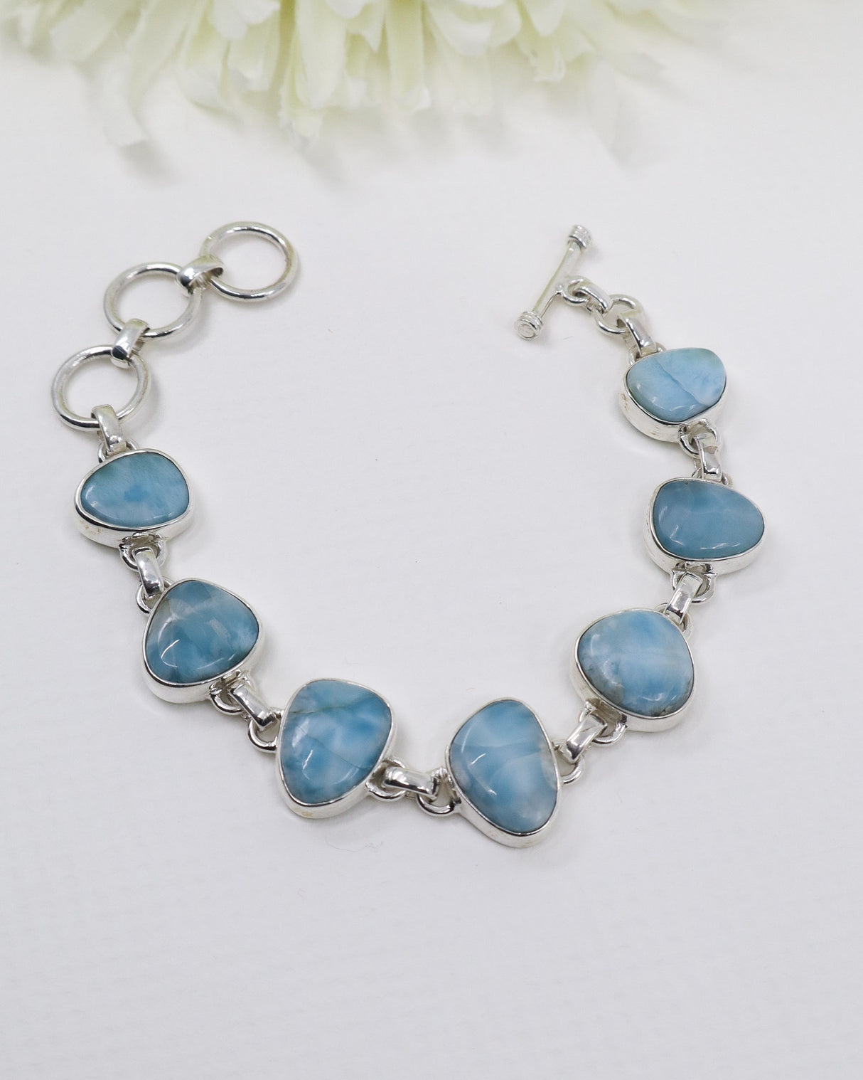 Large polished Larimar sterling silver statement bracelet with natural ocean-blue gemstones and adjustable links.