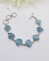 Large polished Larimar sterling silver statement bracelet with natural ocean-blue gemstones and adjustable links.