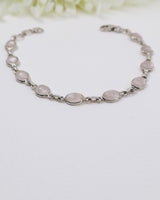 Delicate sterling silver Rose Quartz bracelet with soft pink gemstones displayed beside ruler for size reference.