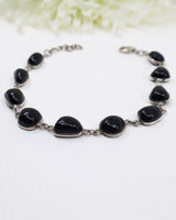 Sterling silver Black Onyx bracelet with polished black gemstones displayed beside ruler for size reference.
