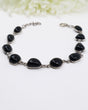 Sterling silver Black Onyx bracelet with polished black gemstones displayed beside ruler for size reference.