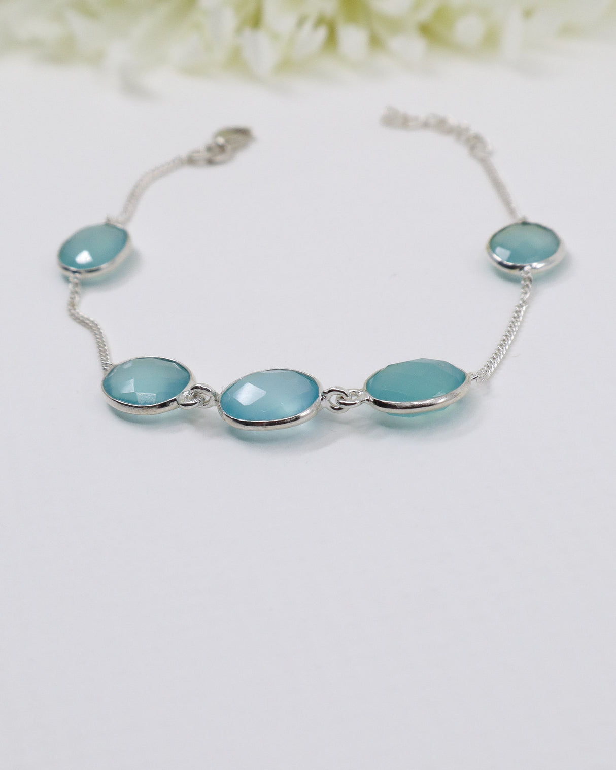 Sterling silver Blue Chalcedony gemstone bracelet with soft blue faceted stones displayed beside ruler for size reference.