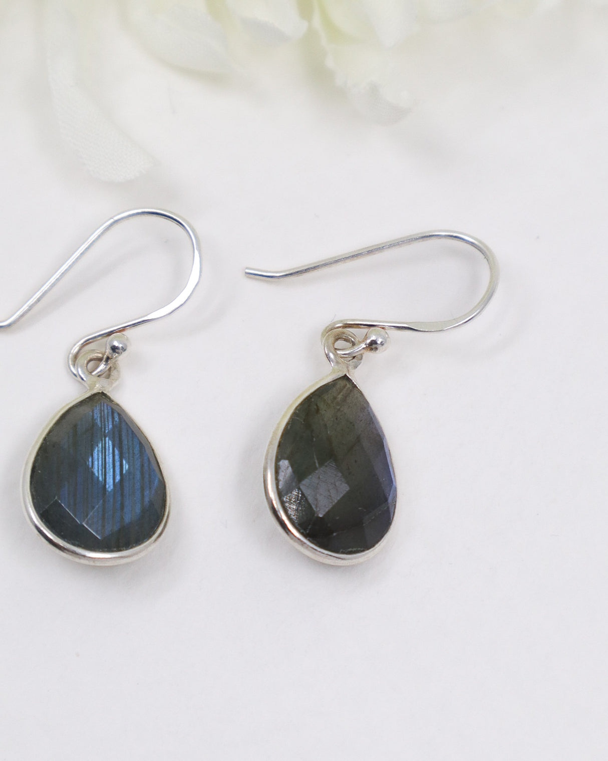 Natural faceted Labradorite sterling silver teardrop earrings with blue flash labradorescence photographed on a soft cream background by Inspired By 3 Australia.