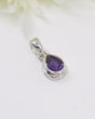 Faceted teardrop Amethyst sterling silver pendant with rich violet tones displayed on a soft white background.