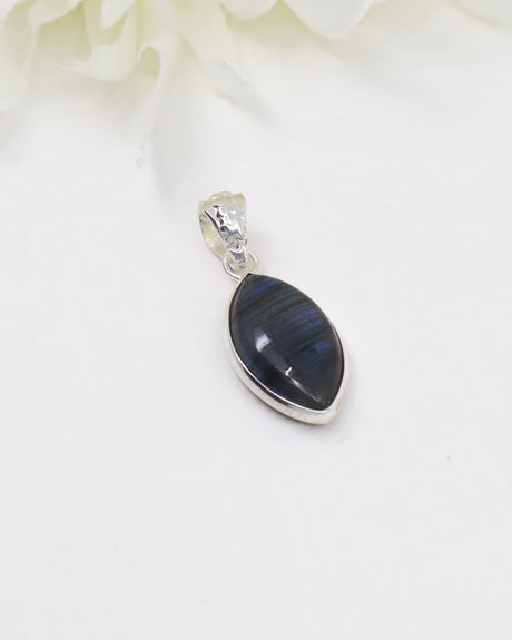 Blue flash Labradorite sterling silver pendant with marquise-shaped gemstone displaying vibrant labradorescence on a white background.