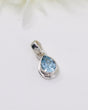 Pear-cut Blue Topaz sterling silver pendant with faceted light blue gemstone on a soft cream background by Inspired By 3 Australia.