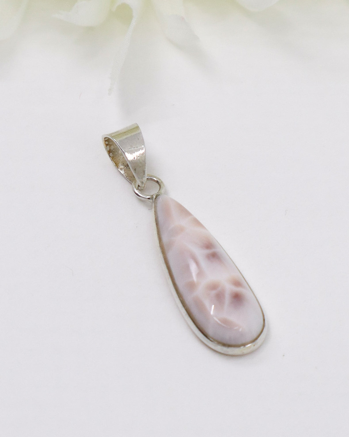 Pink Natrolite “Pink Larimar” sterling silver elongated teardrop pendant with soft blush marbled gemstone.