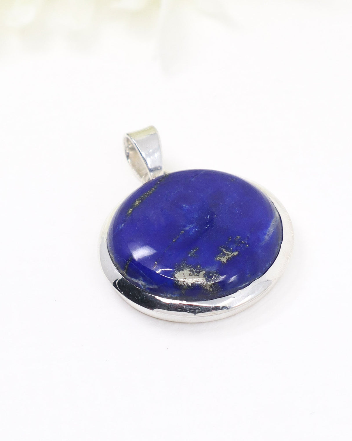 Sterling silver Lapis Lazuli pendant with deep royal blue gemstone and natural Pyrite inclusions on white background.