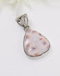 Pink Natrolite (“Pink Larimar”) sterling silver pendant with soft blush orbicular flower patterns photographed on a white background.
