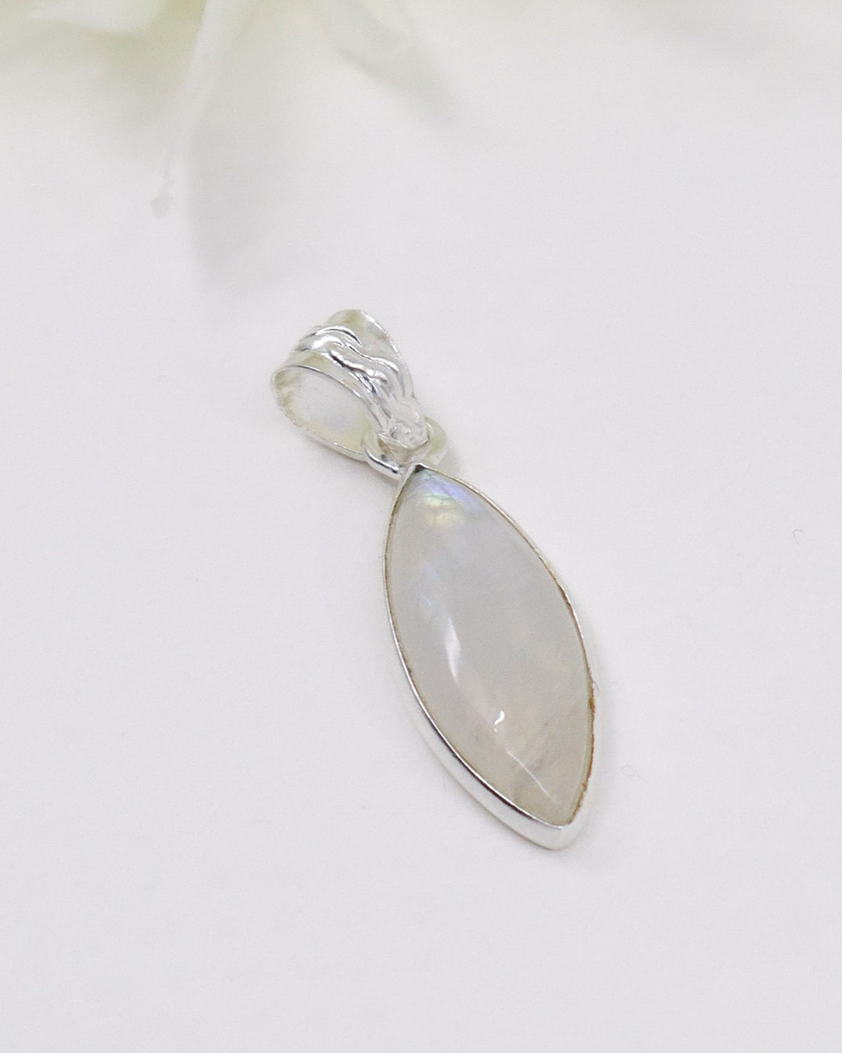 Marquise-shaped Rainbow Moonstone sterling silver pendant with soft blue flash and polished gemstone on a white background.
