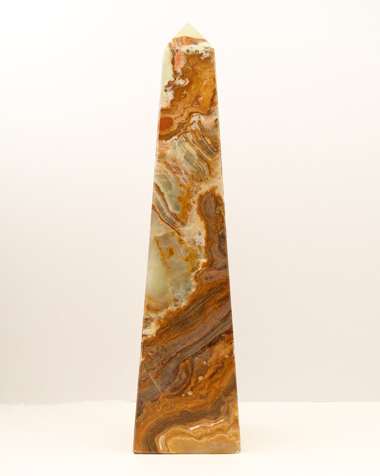 Large polished Green Onyx crystal tower with flowing caramel, green and cream natural banding standing upright on a white background.