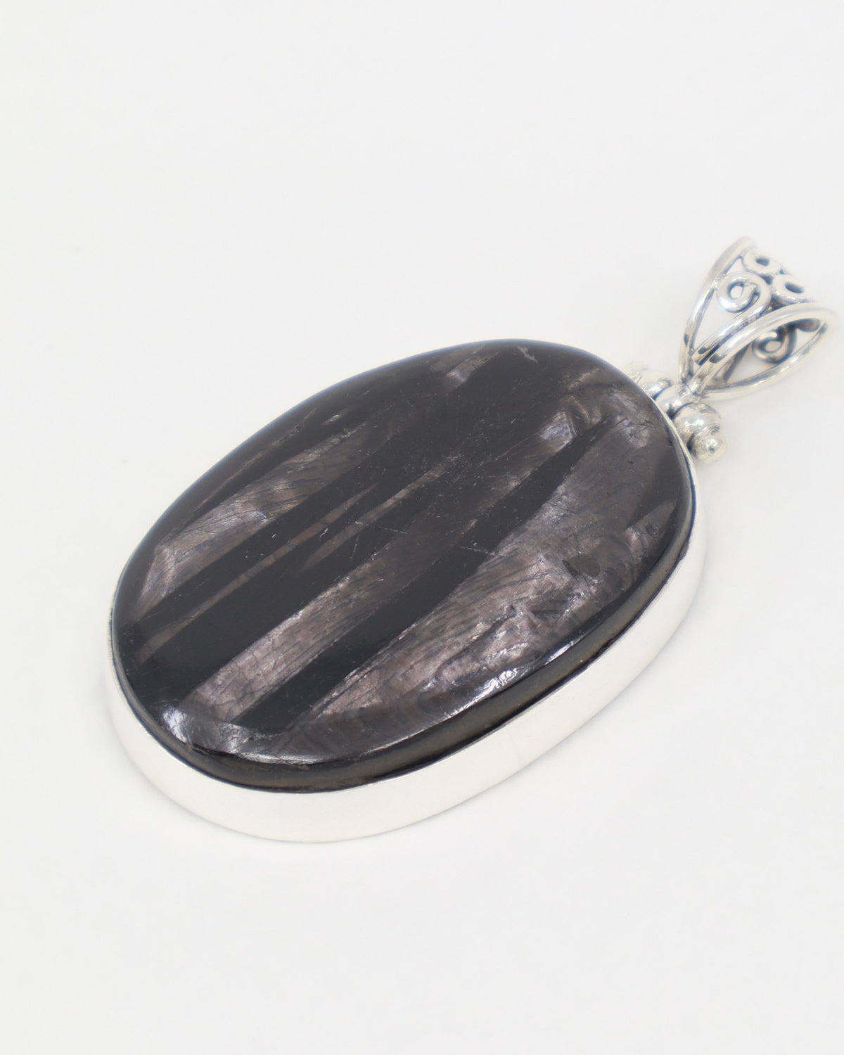 Natural Hypersthene sterling silver pendant with dark charcoal stone, silvery bronze flash, oval gemstone and ornate .925 silver bail.