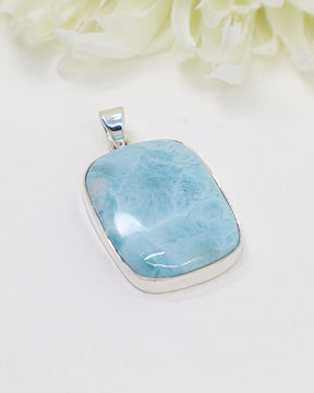 Large rectangular Larimar silver pendant with vivid ocean-blue natural patterns in polished sterling silver setting.