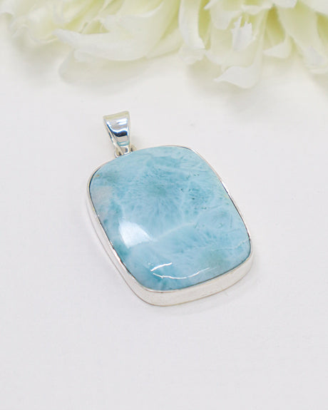 Large rectangular Larimar silver pendant with vivid ocean-blue natural patterns in polished sterling silver setting.