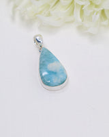 Teardrop Larimar silver pendant featuring dreamy sky-blue and white ocean-like marbling set in polished sterling silver bezel.