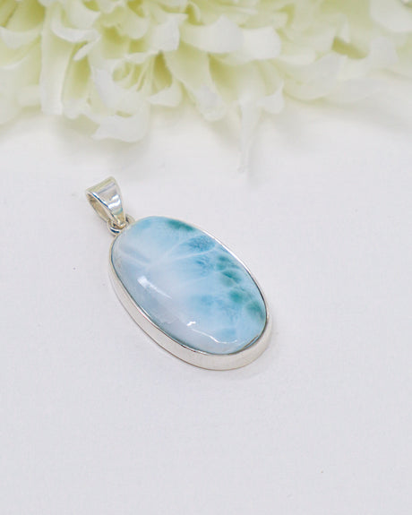 Oval Larimar silver pendant with soft ocean-blue and white natural marbling set in polished sterling silver.