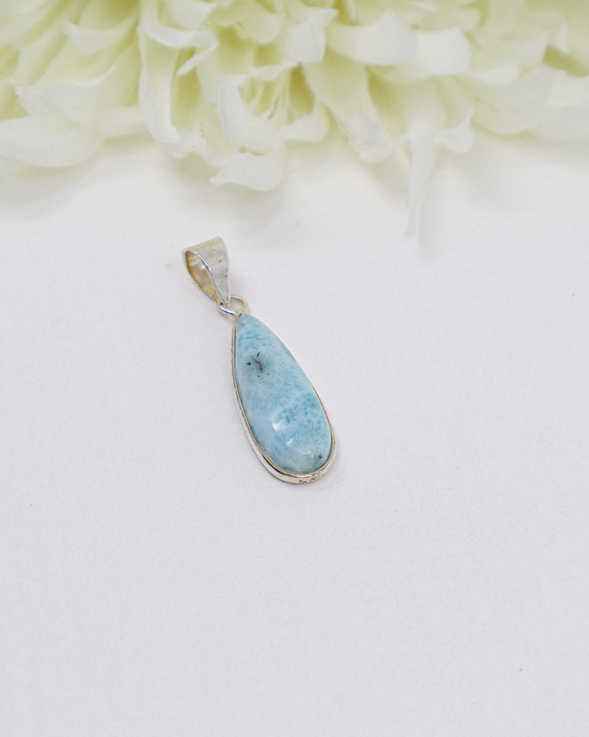 Elegant elongated teardrop Larimar silver pendant featuring natural sky-blue ocean patterns set in polished sterling silver.