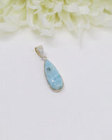 Elegant elongated teardrop Larimar silver pendant featuring natural sky-blue ocean patterns set in polished sterling silver.