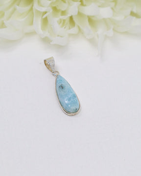 Elegant elongated teardrop Larimar silver pendant featuring natural sky-blue ocean patterns set in polished sterling silver.