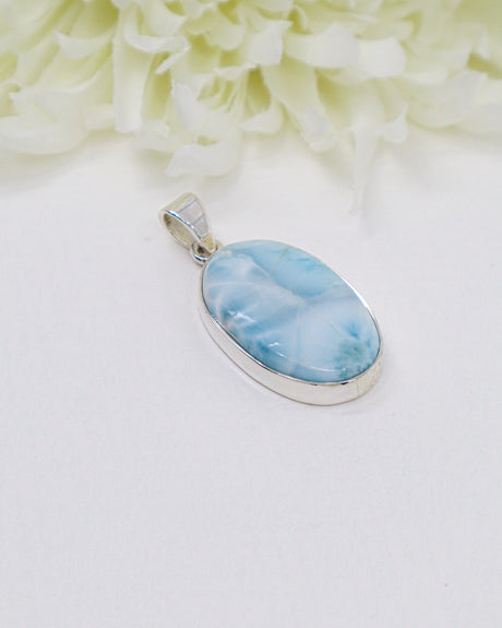 Oval Larimar silver pendant with soft sky-blue and white ocean-like marbling set in polished sterling silver bezel.