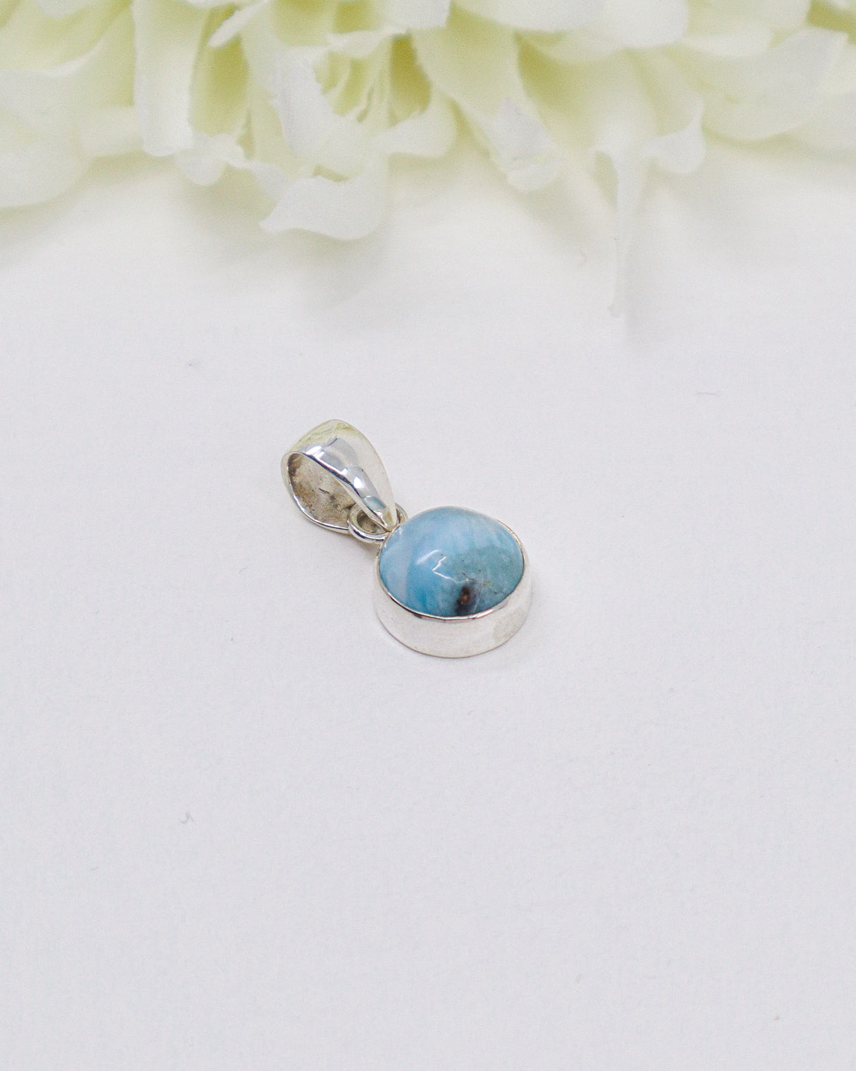 Petite round Larimar silver pendant featuring natural ocean-blue and white marbling set in polished sterling silver.