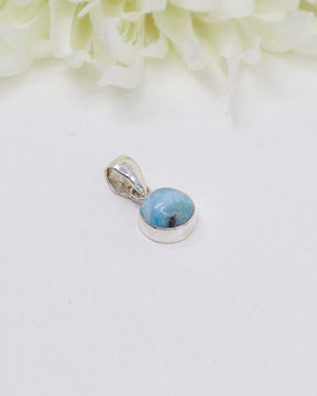 Petite round Larimar silver pendant featuring natural ocean-blue and white marbling set in polished sterling silver.