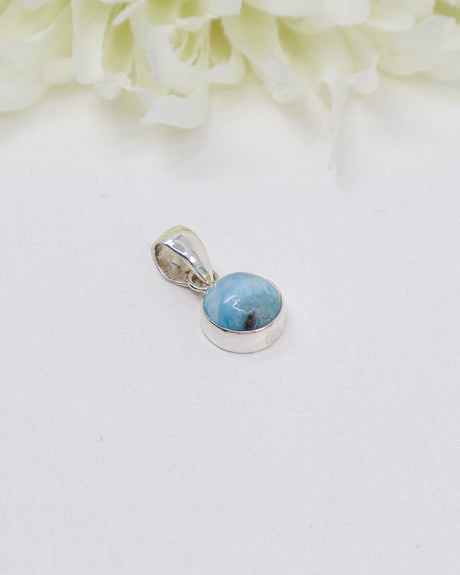 Petite round Larimar silver pendant featuring natural ocean-blue and white marbling set in polished sterling silver.