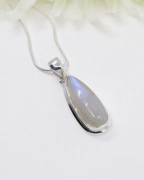 Rainbow Moonstone sterling silver pendant with soft blue flash displayed on silver chain against elegant white background.