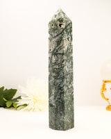 Large polished Moss Agate crystal tower with natural green patterns and sparkling druzy cavity.