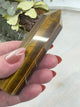 video of 6-Sided Tiger Eye Point 10 cm × 3 cm – golden-brown crystal point symbolising courage, grounding and strength, Inspired By 3 Australia.