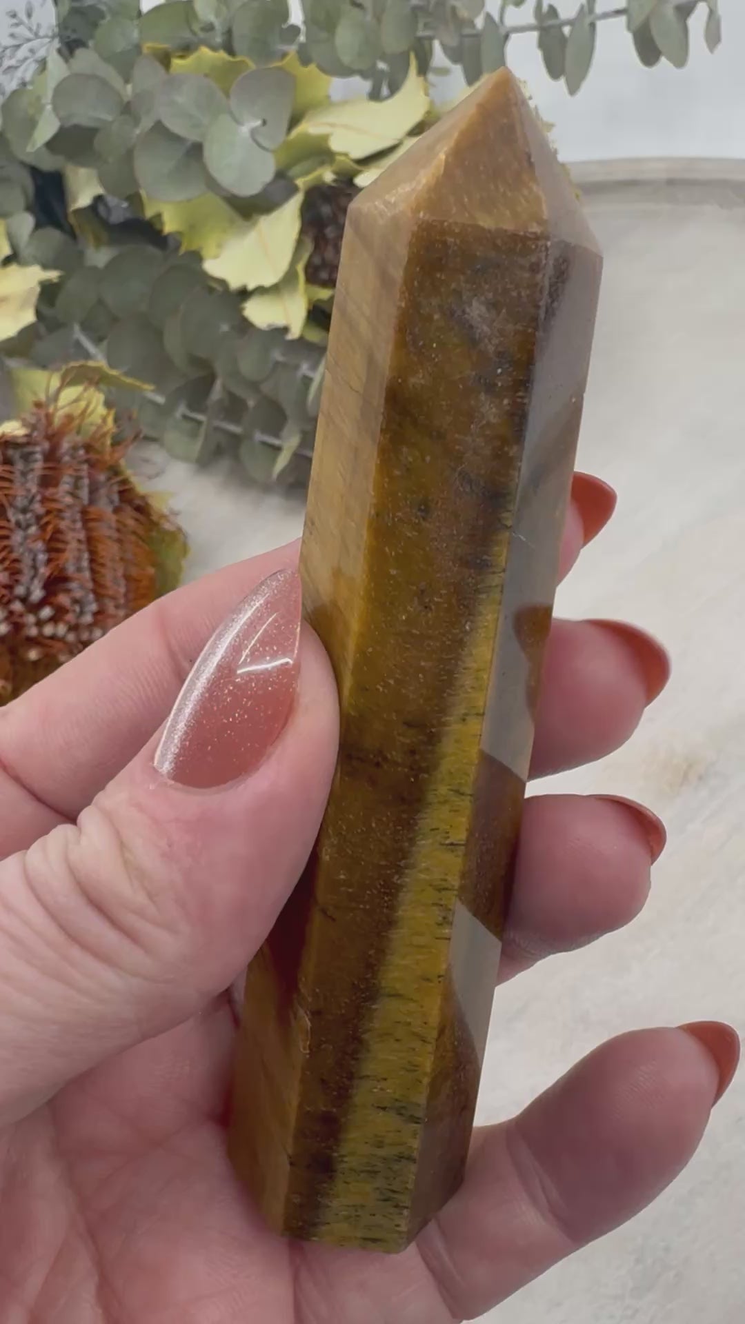 video of 6-Sided Tiger Eye Point 10.5 cm × 2.5 cm – golden-brown crystal point symbolising courage, grounding and focus, Inspired By 3 Australia.