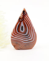 The Oracle's Eye Sardonyx Freeform weighing 155g featuring striking caramel, cream and white concentric banding with a natural eye formation, polished finish and grounding energy.